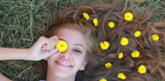 How To Start Feeling At Peace With The Way You Look Girl Lying on Grass with Chrysanthemum